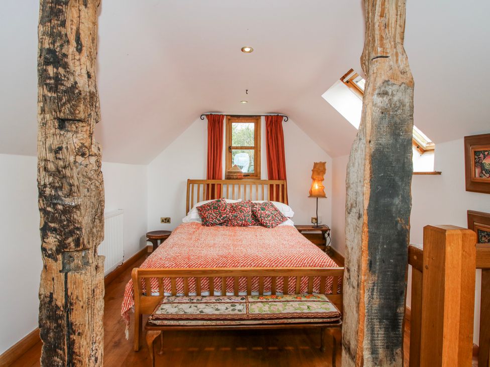 A bedroom with a bed and wooden features at Bell House Cottage Wistanstow near Craven Arms