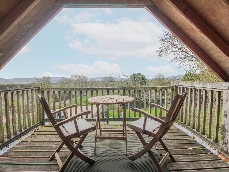 A balcony with table and chairs at Bell House Cottage in Wistanstow near Craven Arms