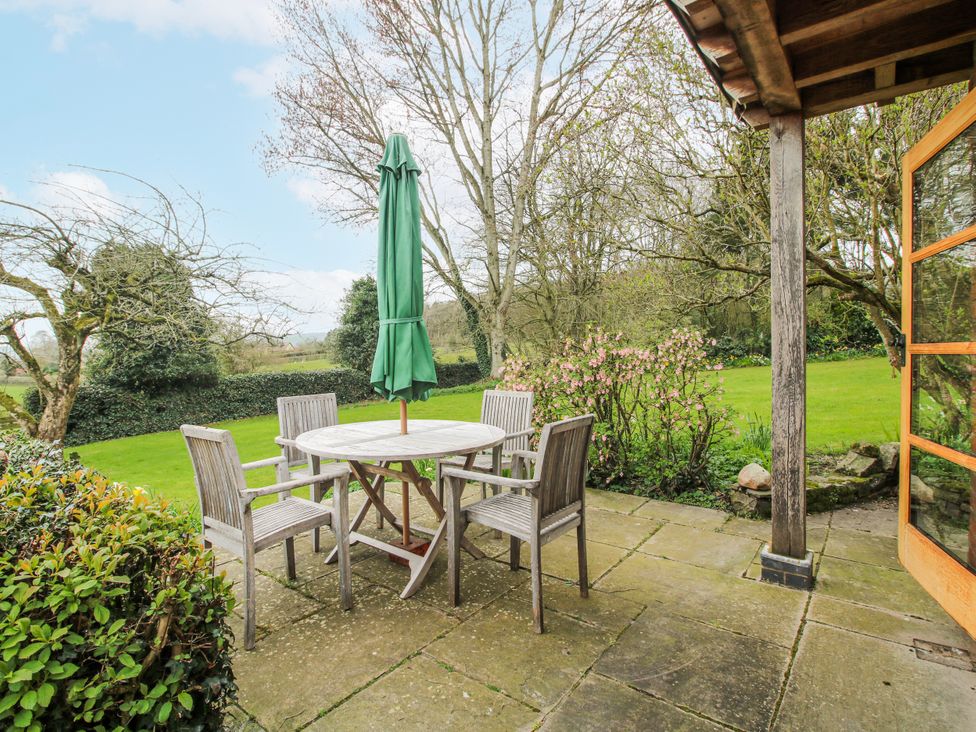 A patio area with a table and chairs at Bell House Cottage in Wistanstow near Craven Arms