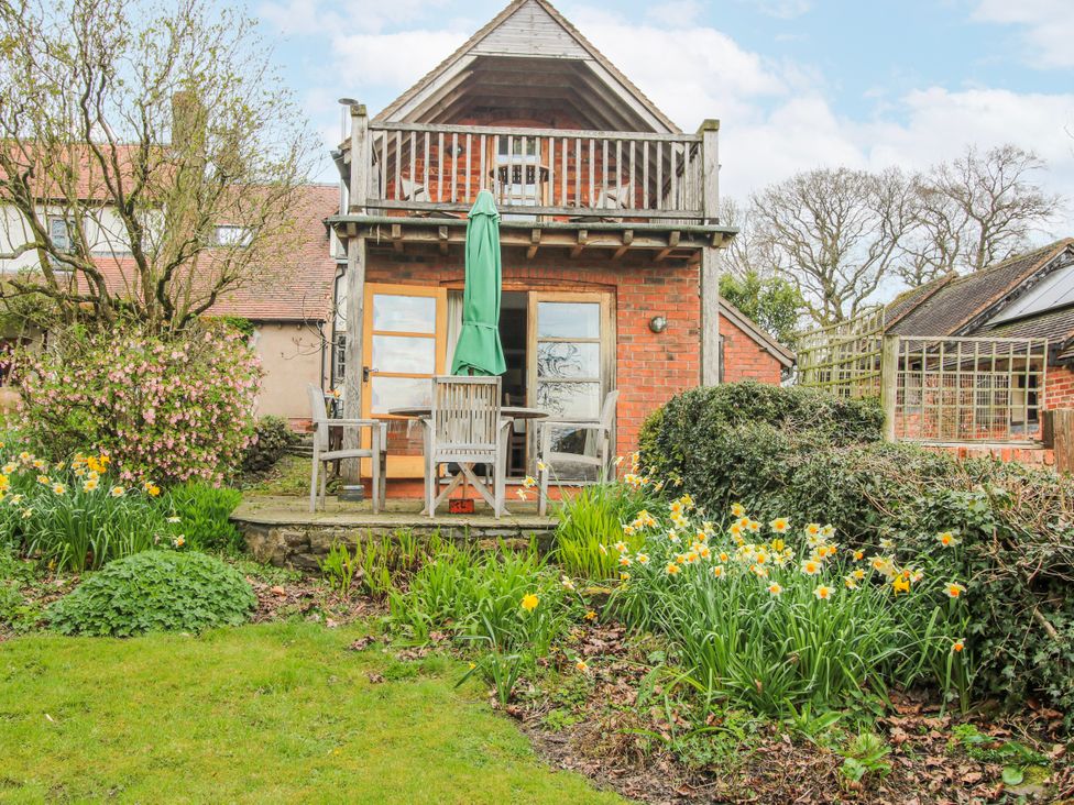 A building with a deck and seating in the garden at Bell House Cottage Wistanstow near Craven Arms