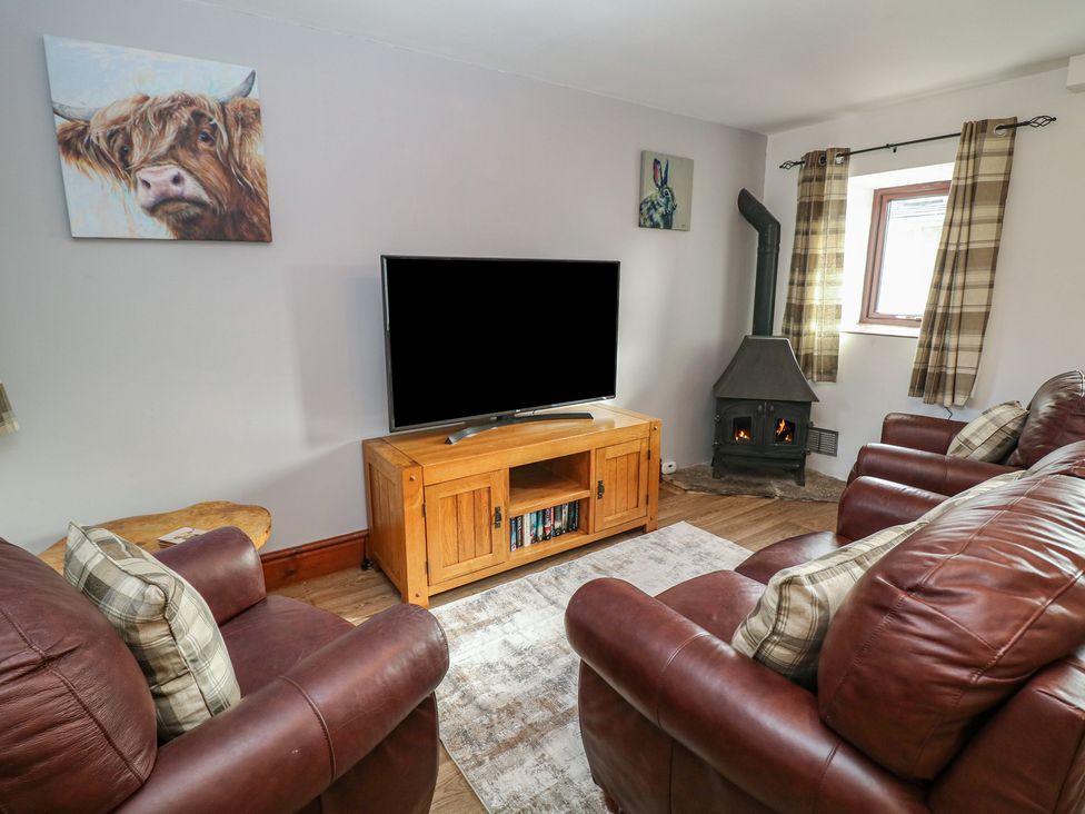 A living room with television and fireplace at Wayside Cottage at Wayside Farm Matlock