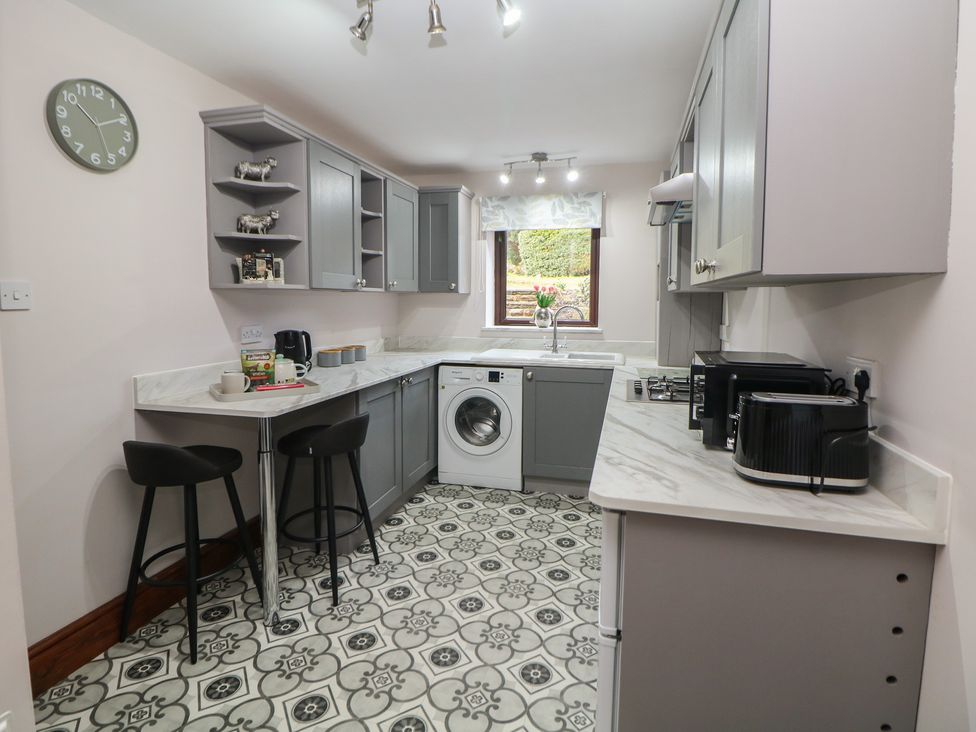 A kitchen with appliances and seating at Wayside Cottage at Wayside Farm Matlock