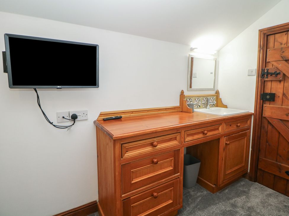 A room with a desk and television at Wayside Cottage at Wayside Farm in Matlock