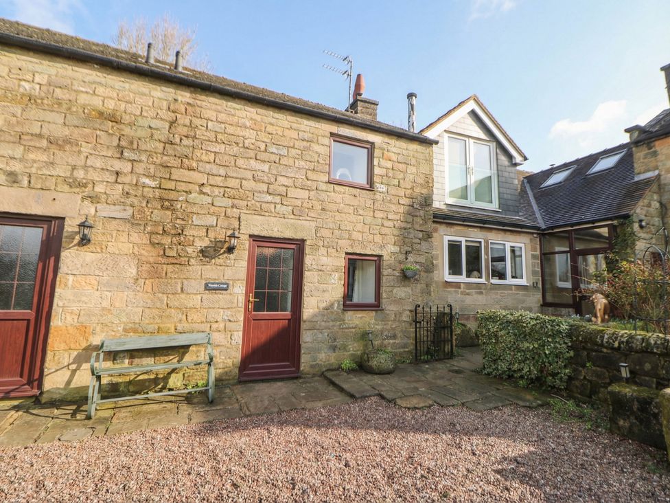 A stone exterior of a property with a bench and doors at Wayside Cottage at Wayside Farm Matlock