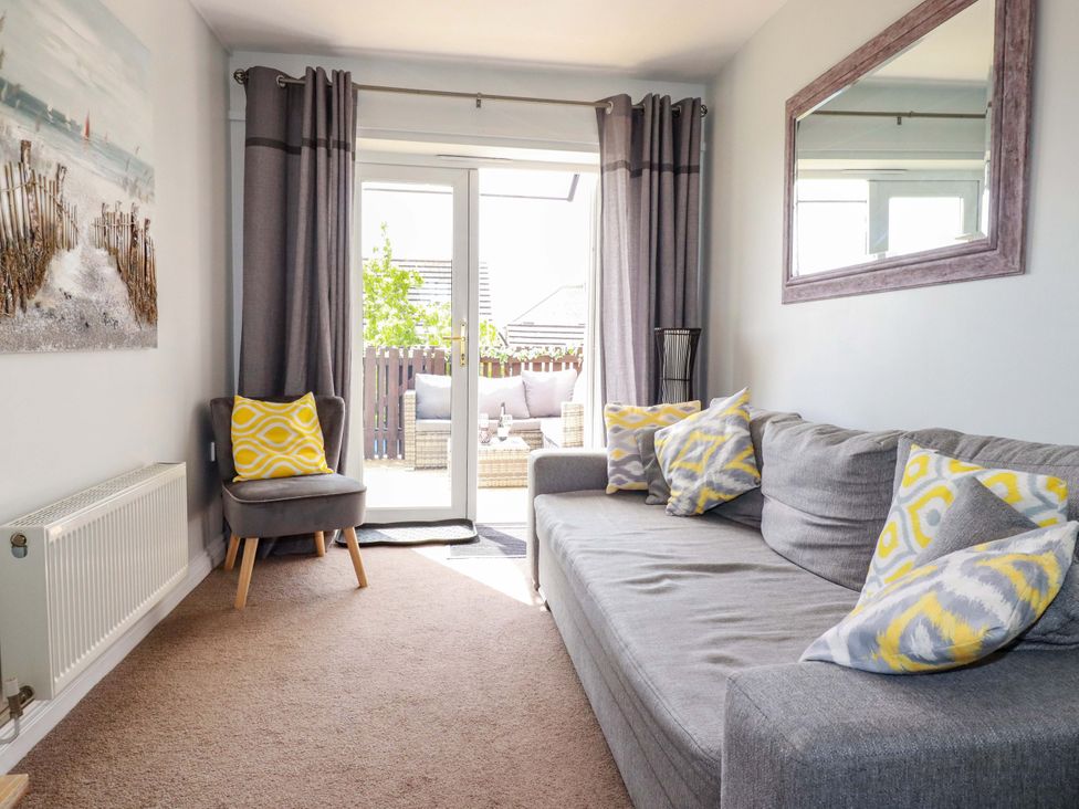 A living room with a sofa and curtains at Tolcarne Reach in Newquay