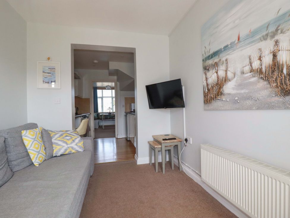 A living room with a sofa and TV at Tolcarne Reach in Newquay