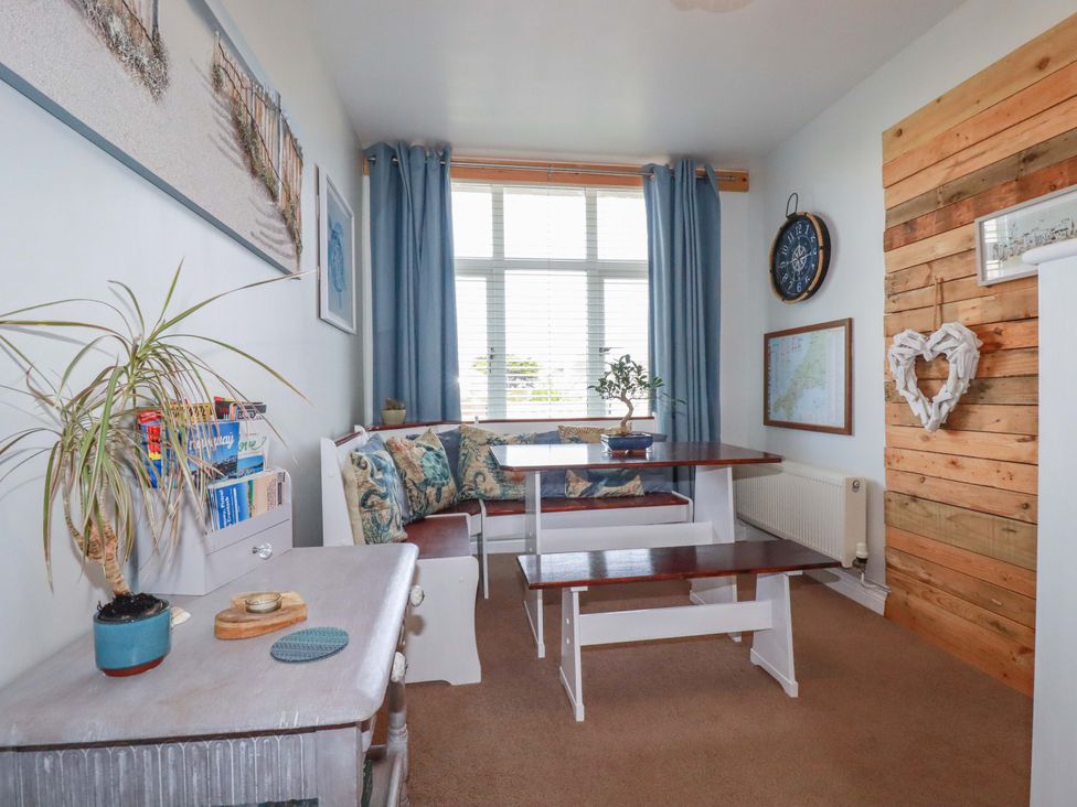 A snug with a table and benches at Tolcarne Reach Newquay