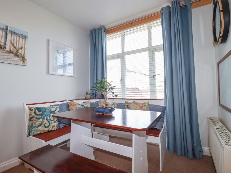 A dining room with a table and benches at Tolcarne Reach in Newquay