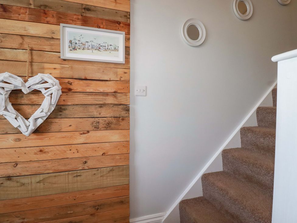 A hallway with wooden wall and a staircase at Tolcarne Reach in Newquay
