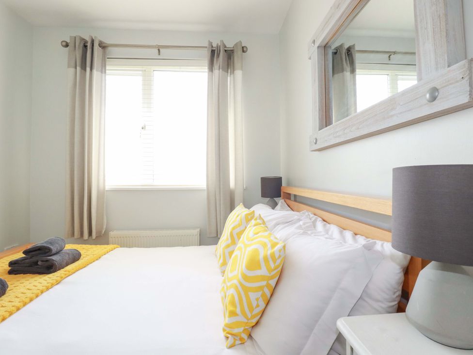 A bedroom with a bed and decorative pillows at Tolcarne Reach in Newquay