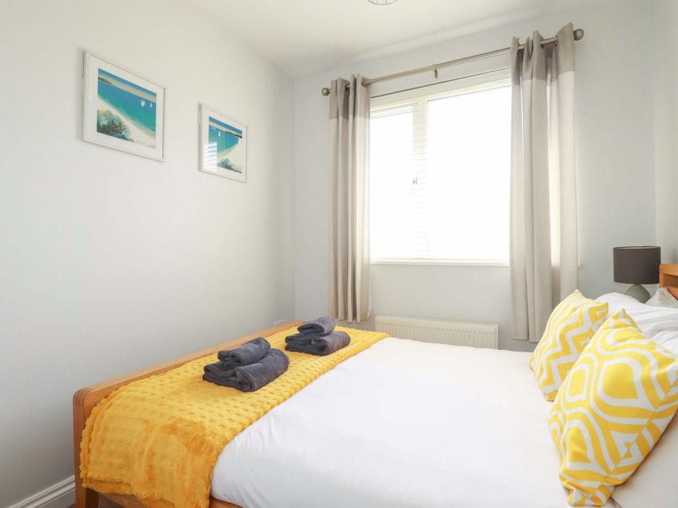 A bedroom with a bed and pillows at Tolcarne Reach in Newquay