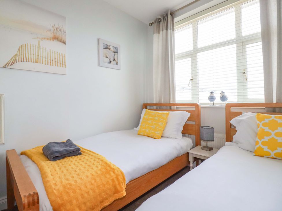 A bedroom with two single beds and wall art at Tolcarne Reach in Newquay