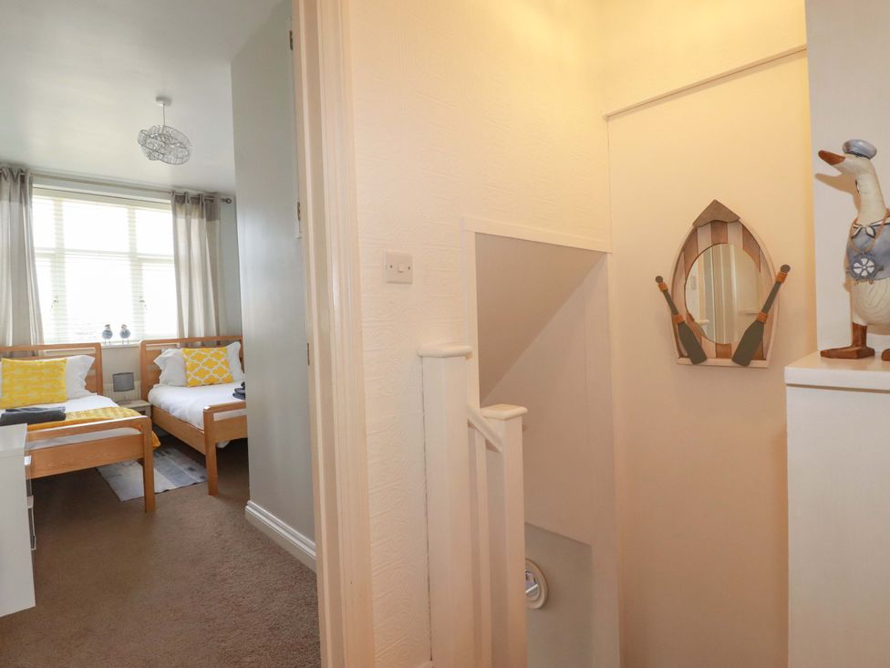 A bedroom with two beds and a staircase at Tolcarne Reach in Newquay