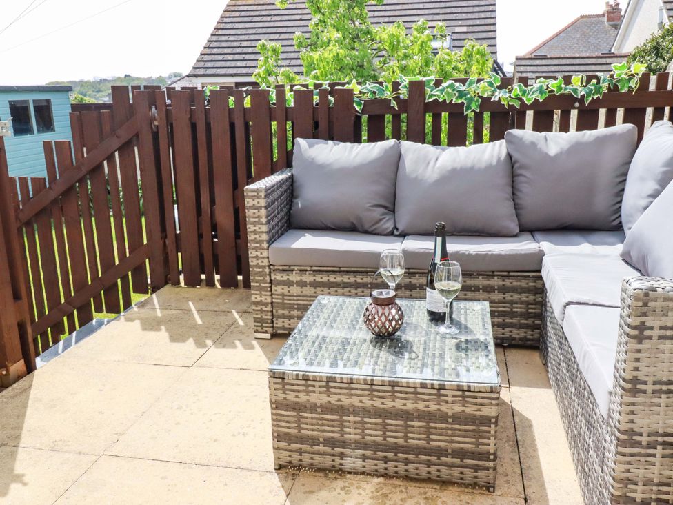 An outdoor seating area with a couch and table at Tolcarne Reach in Newquay