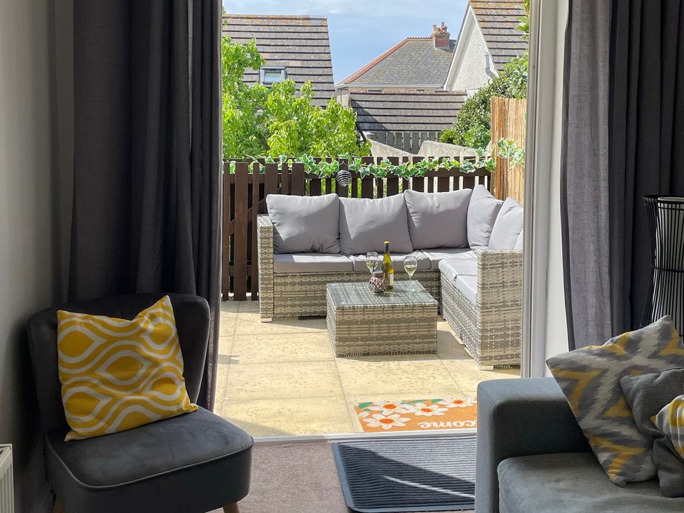 A living room with outdoor seating and a coffee table at Tolcarne Reach in Newquay