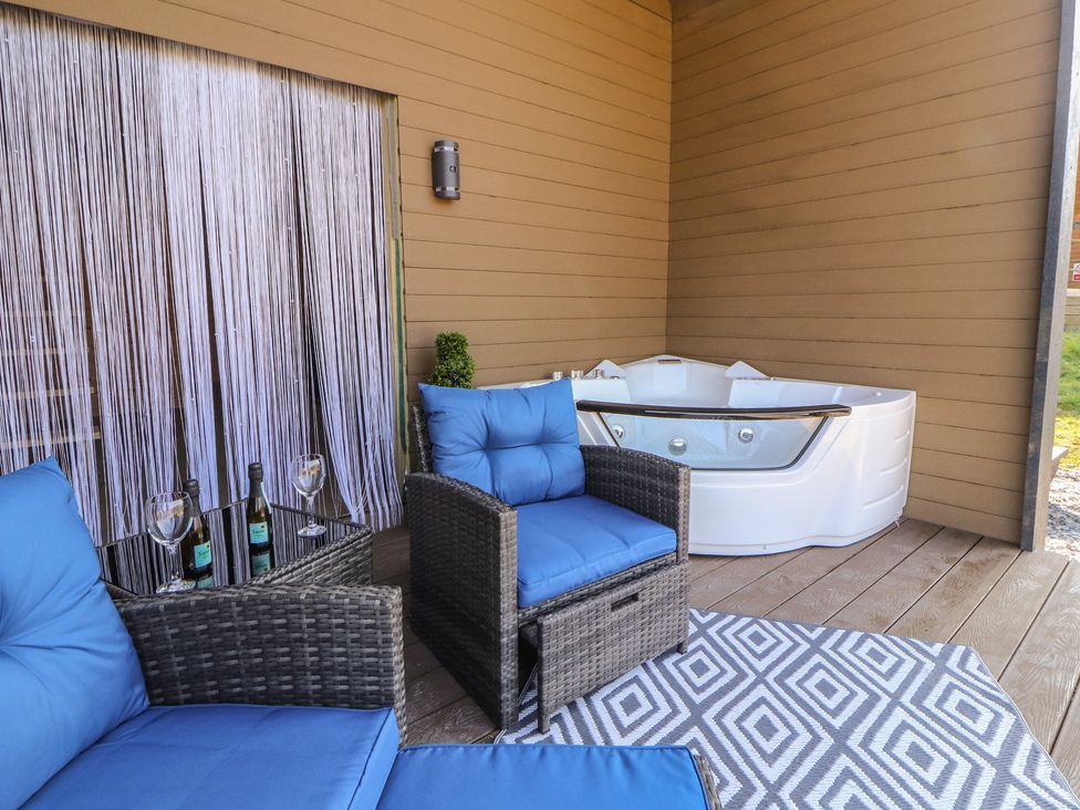 An outdoor patio with seating and a hot tub at Bluebelle - Crossgate Luxury Glamping Hartsop