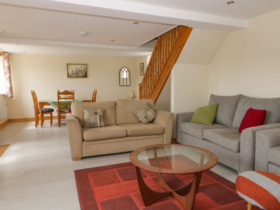 A living room with a sofa and dining area at Lavender Lodge in Hull