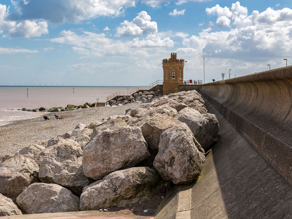 A beach with a tower and rocks at Lavender Lodge in Hull