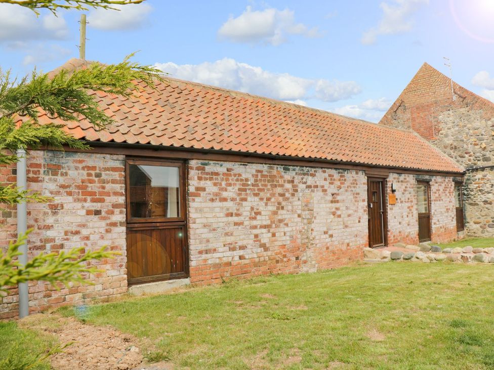 An exterior view of a brick building with a roof and green grass at Meadow View in Hull