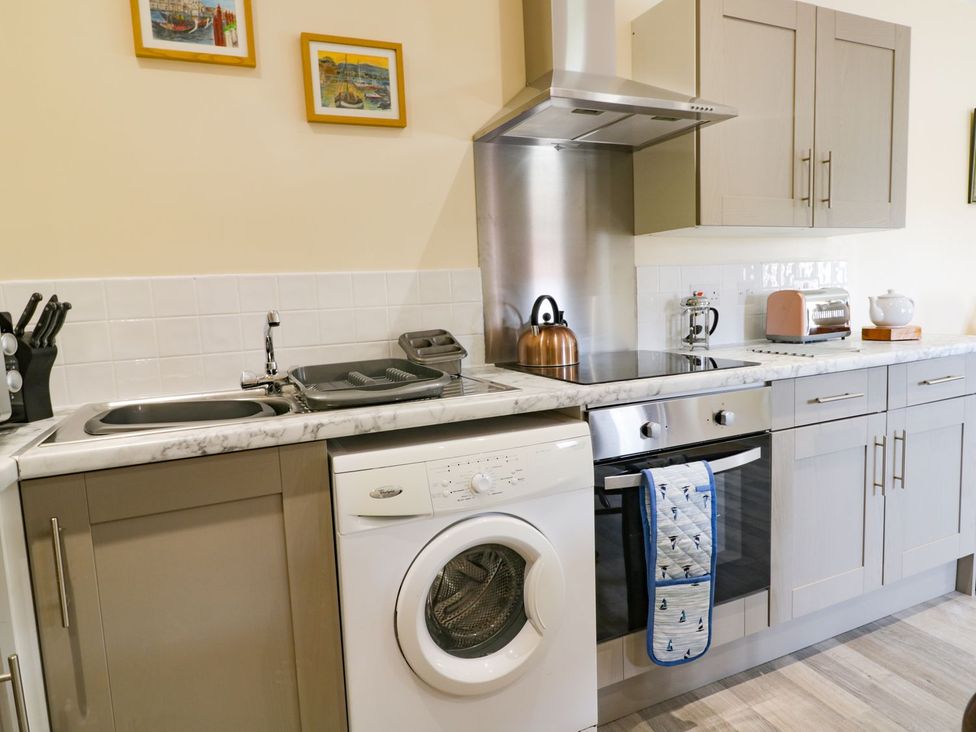 A kitchen with a washing machine, stove, and toaster at Meadow View in Hull