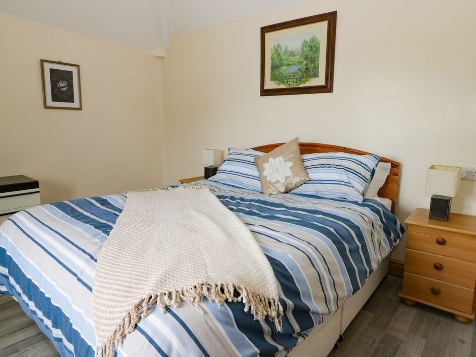 A bedroom with a bed and nightstand at Meadow View in Hull