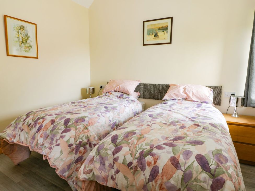 A bedroom with two beds and a bedside table at Meadow View in Hull