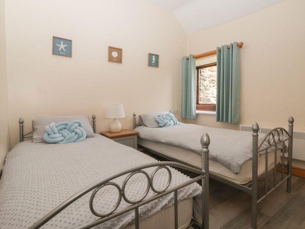 A bedroom with two beds and a nightstand at Meadow View in Tunstall near Withernsea