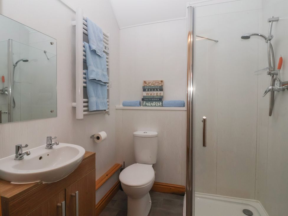 A bathroom with a shower, toilet, and sink at Meadow View in Tunstall near Withernsea