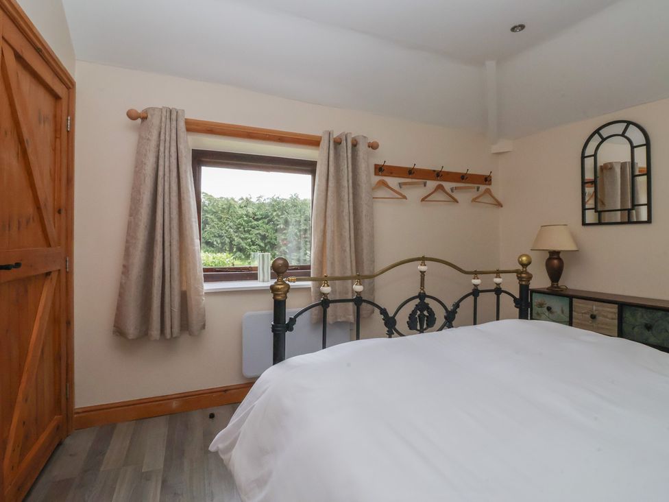 A bedroom with a bed and window at Meadow View Tunstall near Withernsea