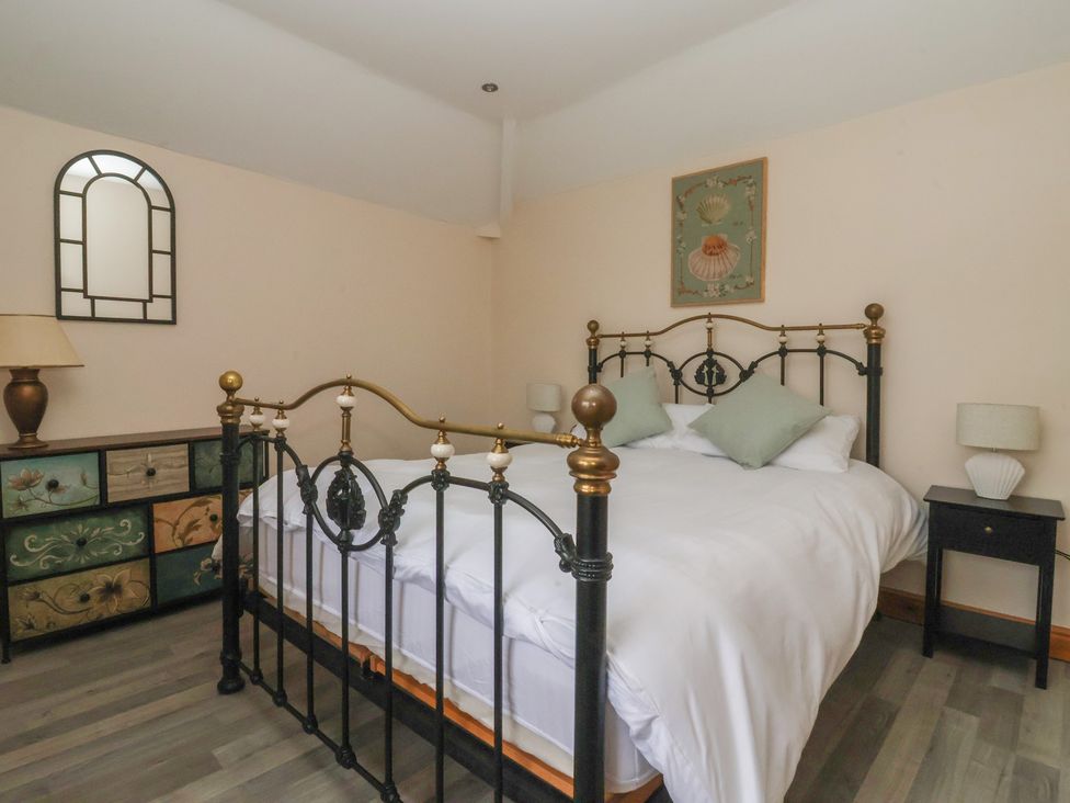 A bedroom with a bed and nightstand at Meadow View in Tunstall near Withernsea