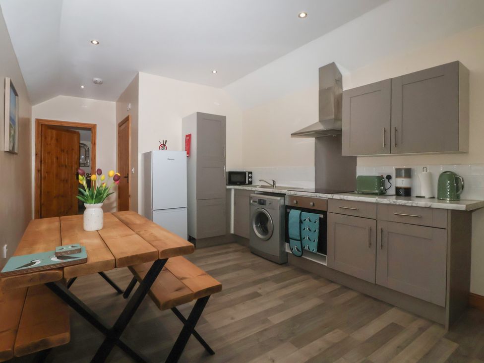 A kitchen with a dining table and appliances at Meadow View in Tunstall near Withernsea