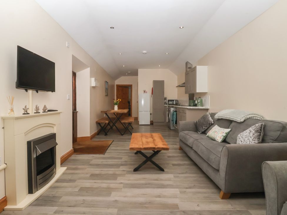 A living room with a television and dining table at Meadow View Tunstall near Withernsea