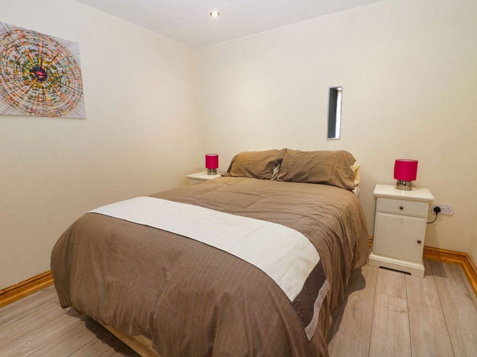 A bedroom with a bed and nightstands at Mulberry Manor in Hull