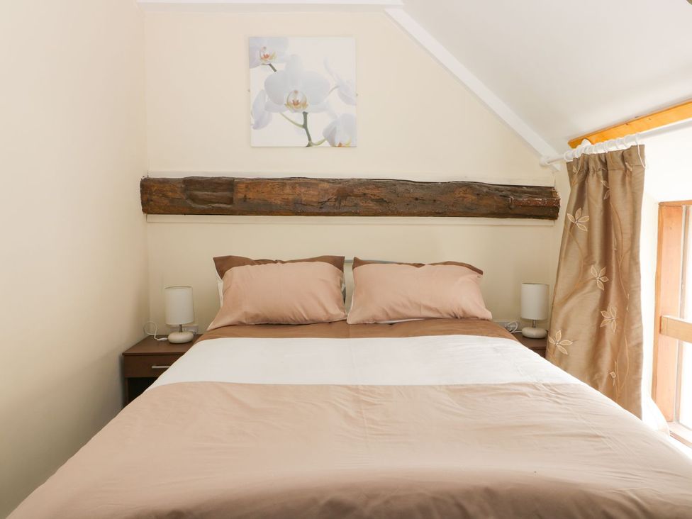 A bedroom with a bed and nightstand at Mulberry Manor in Hull