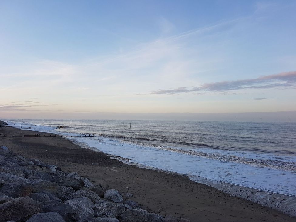 A beach with waves and rocks at Mulberry Manor in Hull