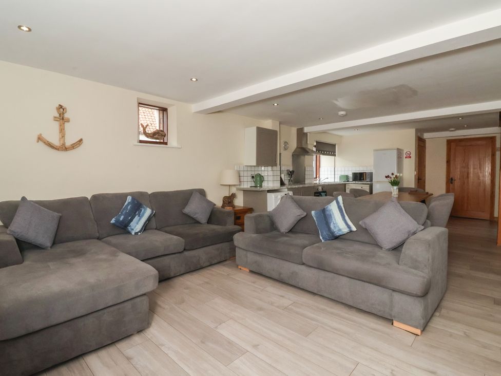 A living room with a sofa and kitchen area at Mulberry Manor Tunstall near Withernsea