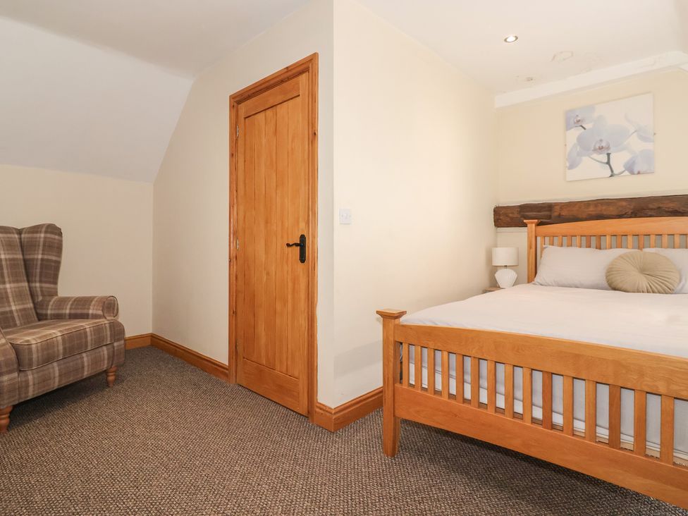 A bedroom with a bed and a chair at Mulberry Manor in Tunstall near Withernsea