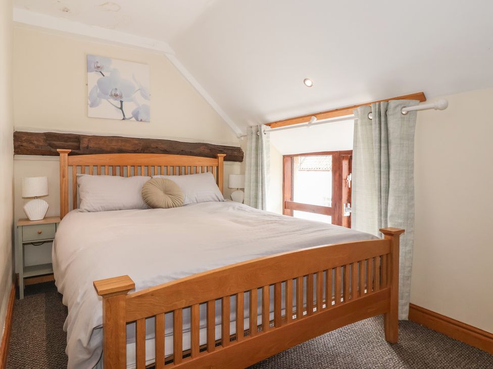 A bedroom with a wooden bed and bedside tables at Mulberry Manor in Tunstall near Withernsea