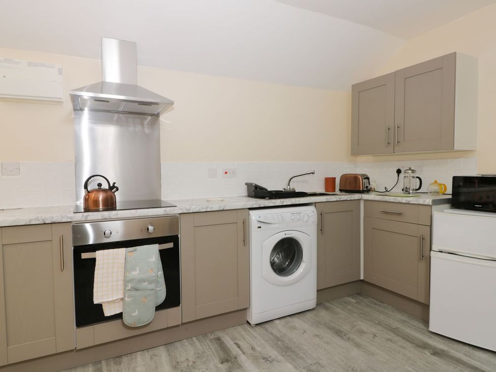 A kitchen with various appliances at Honeybee Cottage in Hull