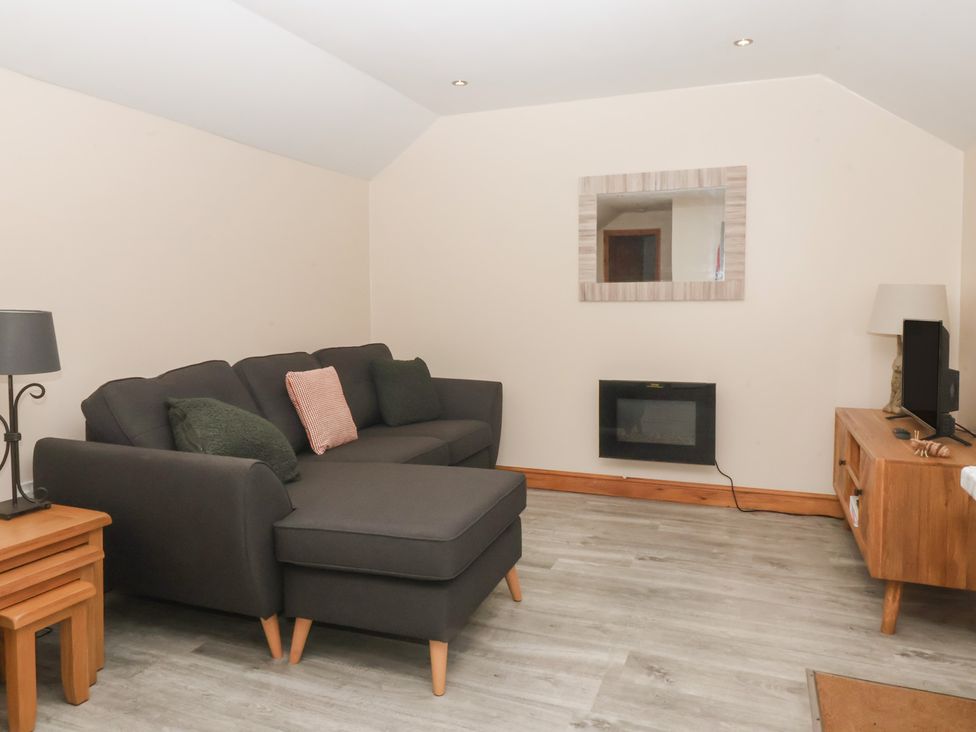 A living room with a sofa and television at Honeybee Cottage in Withernsea