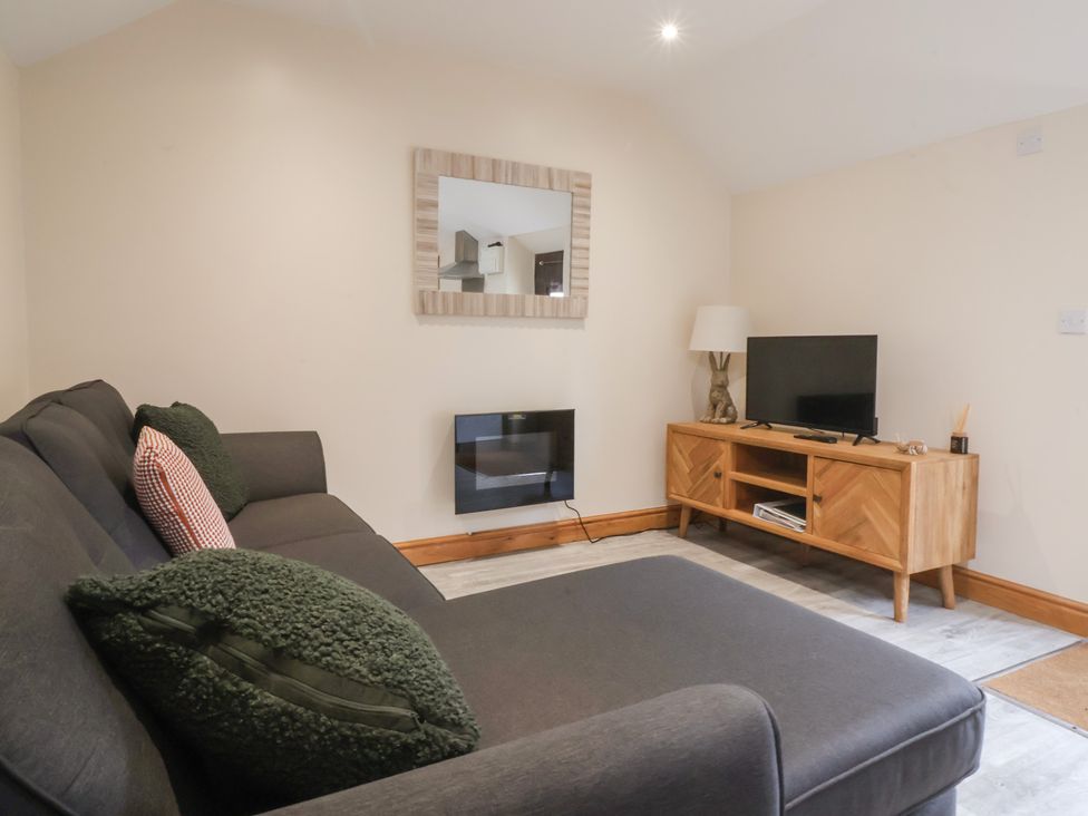 A living room with a television and a sofa at Honeybee Cottage in Withernsea