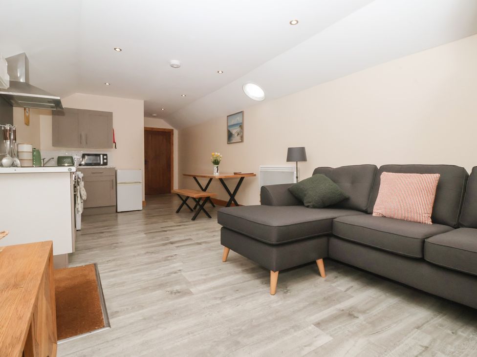 A kitchen with a sofa and dining table at Honeybee Cottage in Withernsea