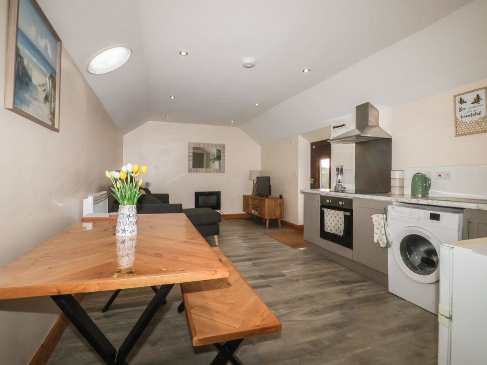 A living room with a sofa and dining table at Honeybee Cottage in Withernsea