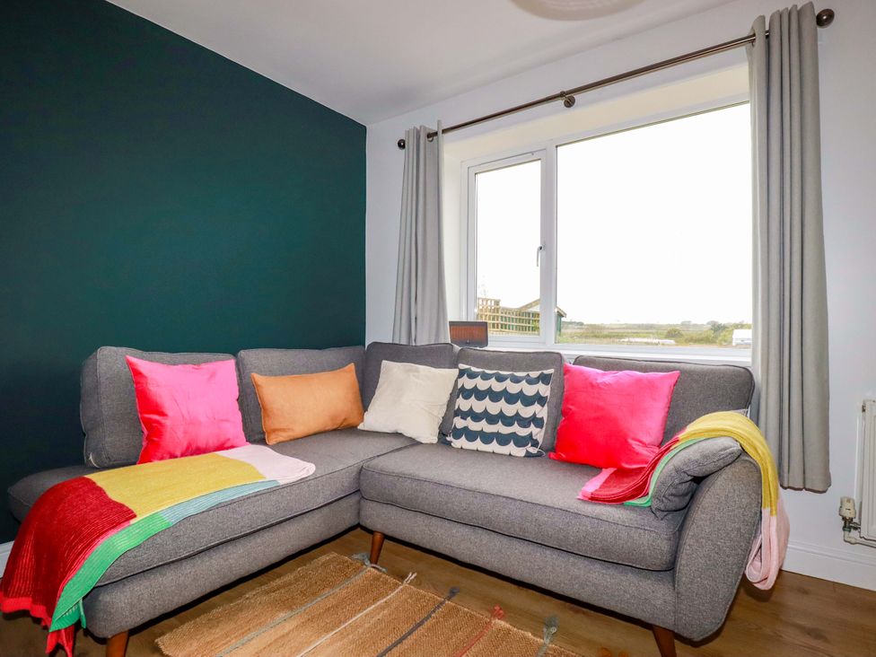 A living room with a gray sofa and colorful cushions at Trelowen in Trenance