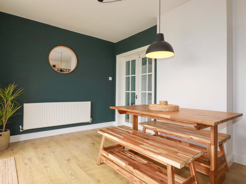 A dining room with a table and benches at Trelowen in Trenance