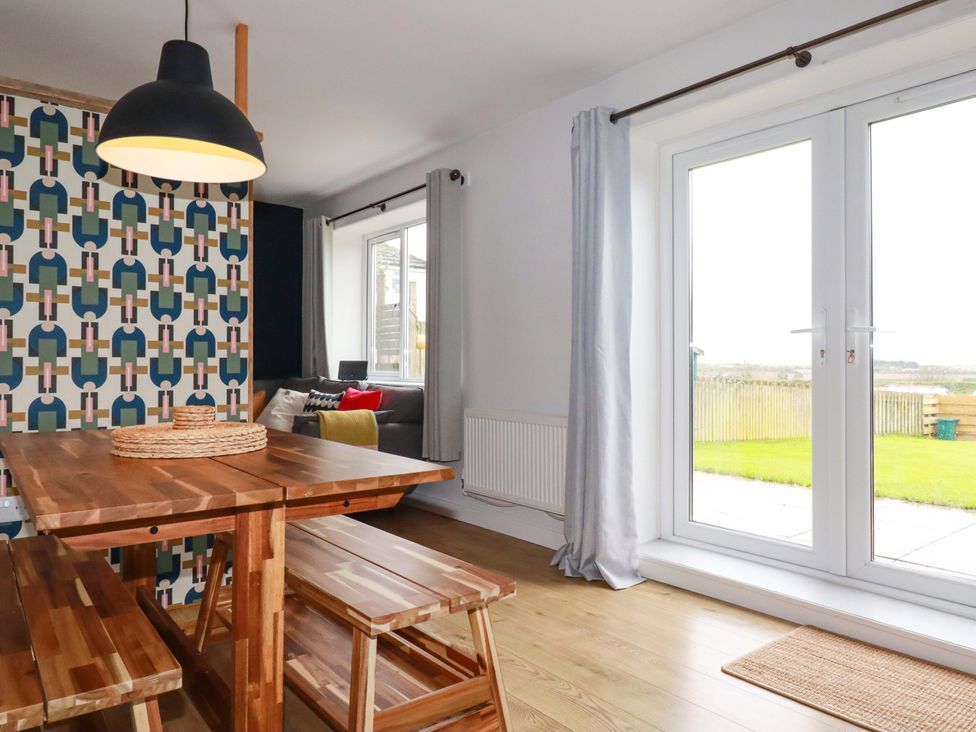 A dining room with a table and benches at Trelowen in Trenance