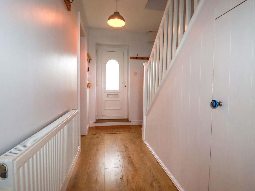 A hallway with a door and staircase at Trelowen in Trenance