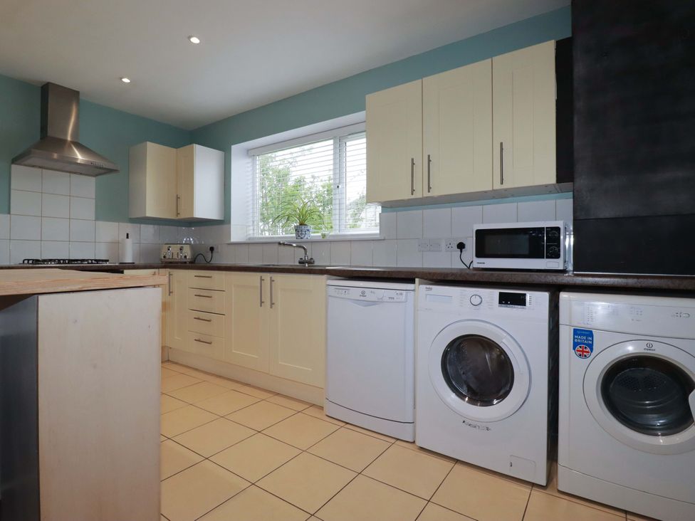 A kitchen with appliances and cabinets at Trelowen in Trenance