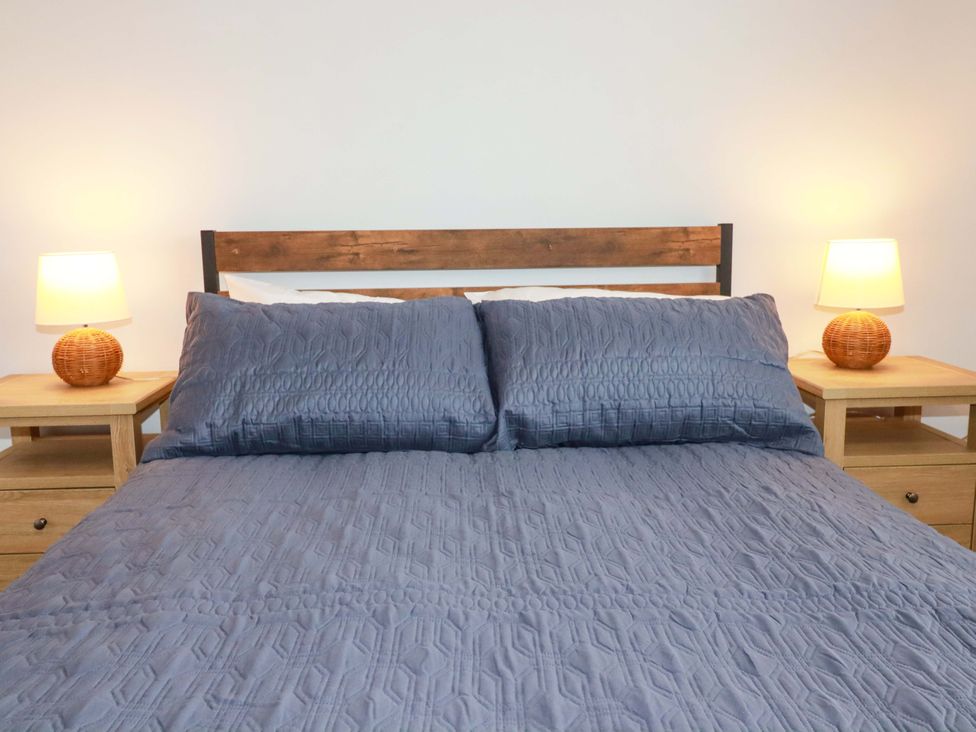 A bedroom with a bed and bedside tables at Trelowen in Trenance