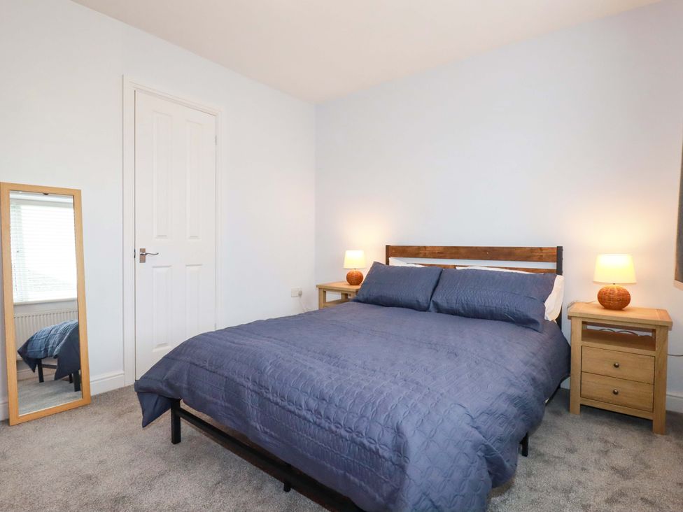 A bedroom with a bed and nightstands at Trelowen in Trenance